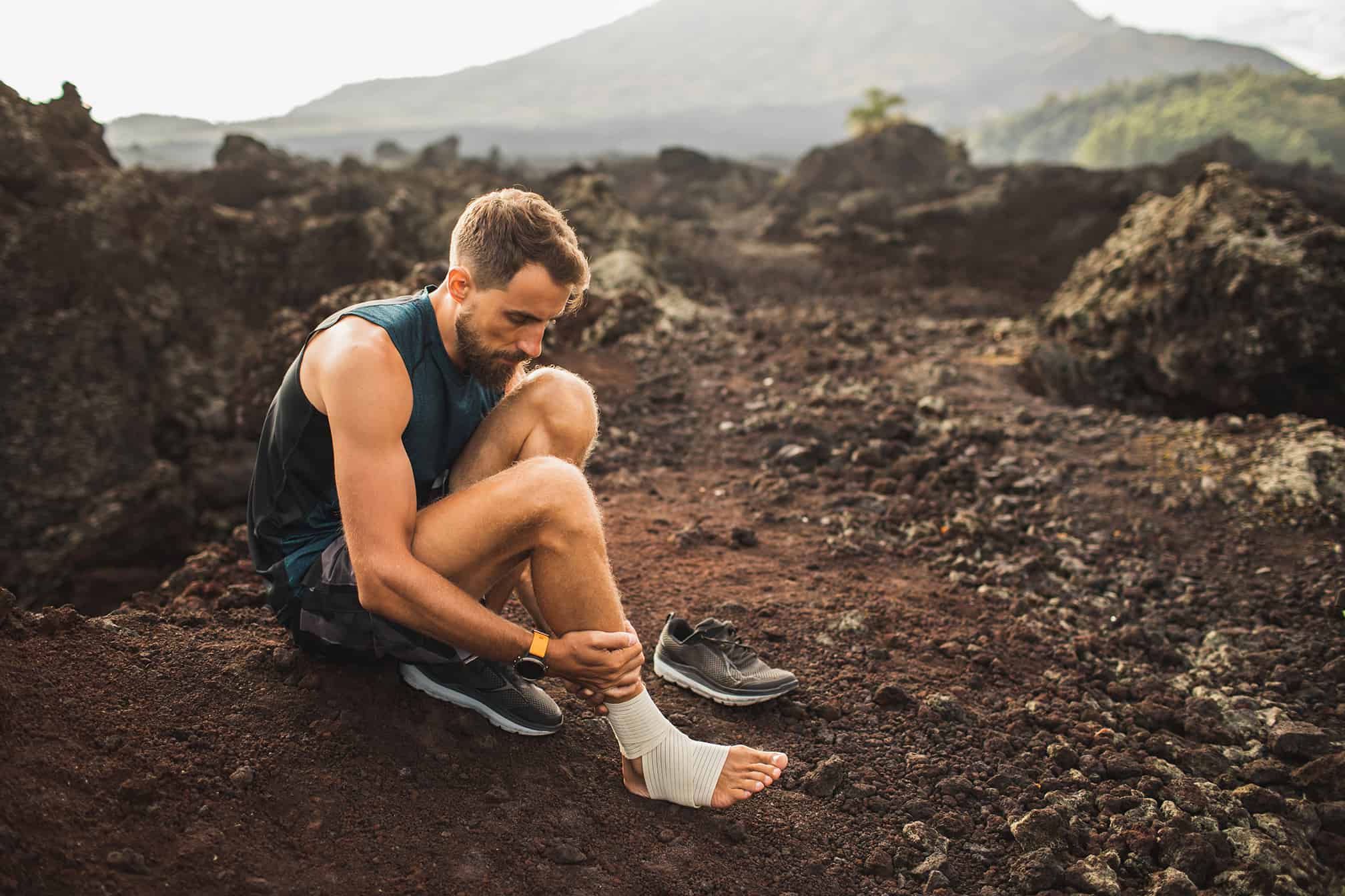 male-runner-bandaging-injured-ankle-injury-leg
